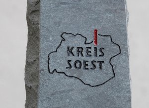 Auf der Vorderseite der Stele sind die Kreisgrenzen und das Logo des Kreises Soest abgebildet, auf der Rückseite befindet sich eine Inschrift auf einem Edelstahlschild. Foto: Thomas Weinstock/Kreis Soest