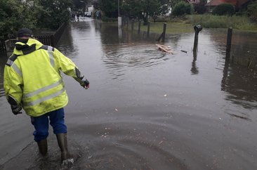 Ein Mann stapft durch Hochwasser. Foto: Thorsten Krabbe/Kreis Soest