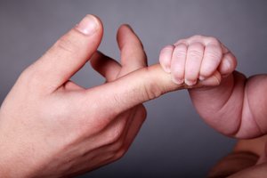 Adoption. Foto: © Nick Freund - Fotolia.com Babyhand greift Finger eines Erwachsenen. Foto: © Nick Freund - Fotolia.com