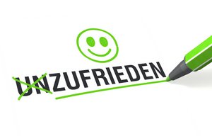 Das Wort Unzufrieden in schwarzer Schrift, die ersten beiden Buchstaben U und N sind durchgestrichen. Dahinter ein lächelnder Smilie. Foto:  Oliver Boehmer - bluedesign® - Fotolia.com