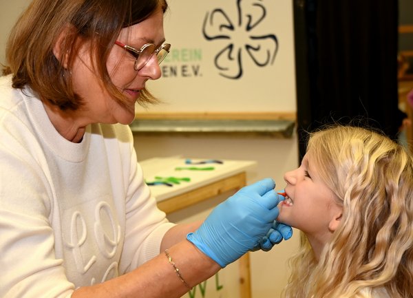 Die Zähne werden mit fluoreszierender Farbe gefärbt Die Zähne werden mit fluoreszierender Farbe gefärbt