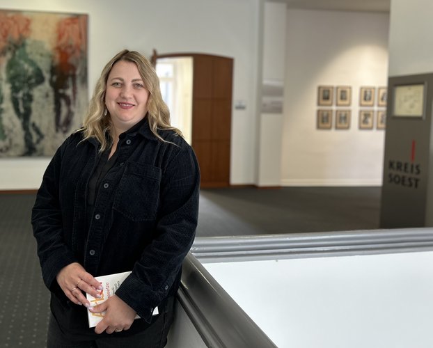 Bachelor of Laws - Teilzeit Eine Frau steht mit einem Gesetz im Bereich des Sitzungstraktes des Kreishauses.