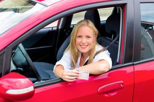 Frau mit Führerschein in der Hand in einem Auto. Foto: © Gina Sanders - Fotolia