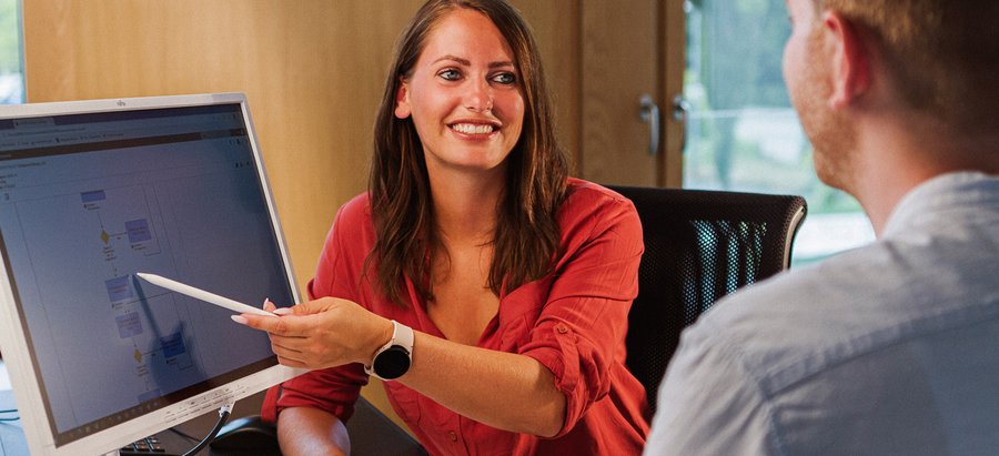 Eine Frau erläutert einen Prozessablauf am Bildschirm. Foto: Thomas Grimm