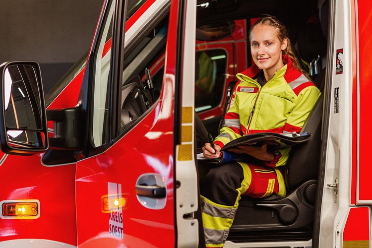 Eine junge Frau in Dienstkleidung protokolliert einen Einsatz vom Fahrersitz. Foto: Thomas Grimm