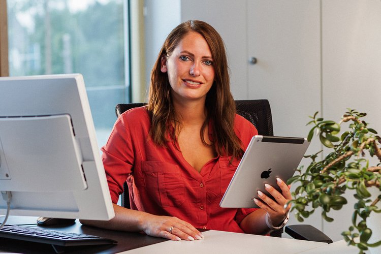 Eine junge Frau hält ein iPad in der Hand. Foto: Thomas Grimm