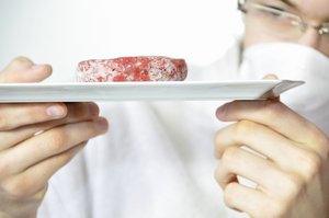 Schlachttier- und Fleischuntersuchung. Foto: © PHILETDOM - Fotolia.com Mann kontrolliert Fleisch. Foto: © PHILETDOM - Fotolia.com