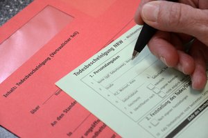 Todesbescheinigung. Foto: Judith Wedderwille/Kreis Soest Hand mit Kugelschreiber über dem Formular einer Todesbescheinigung. Foto: Judith Wedderwille/Kreis Soest